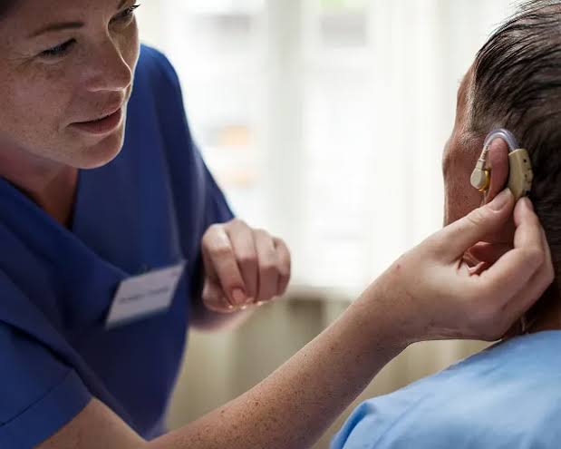 A clinician fitting a tVNS ear electrode for a patient